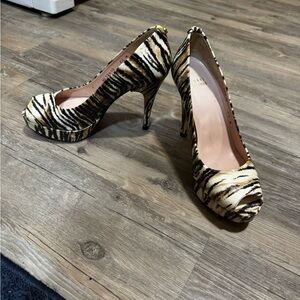 Stuart Weitzman peep-toe platform pumps featuring a tiger animal print pattern.